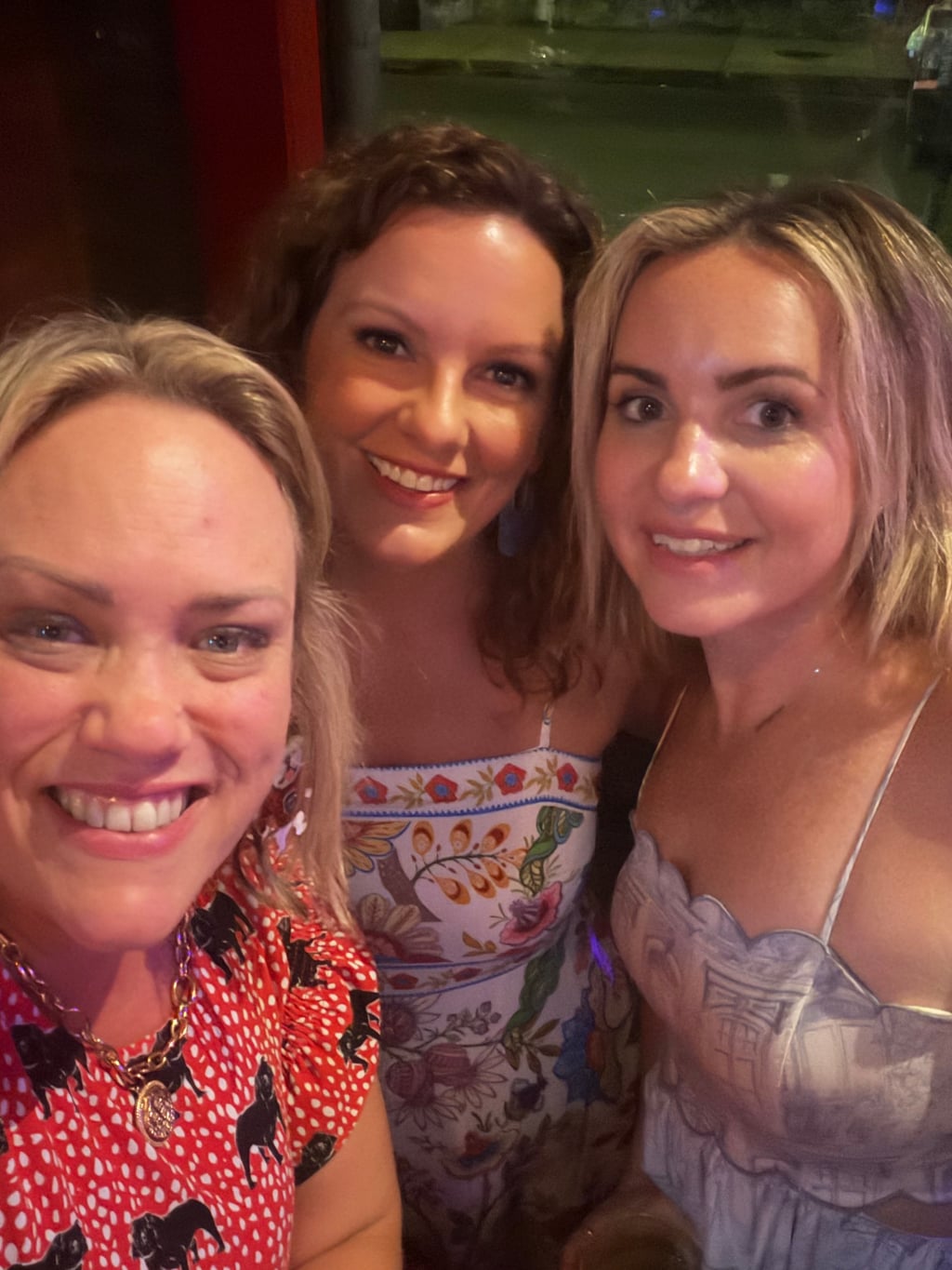 Three friends smiling at an Athens Scoop Dinner Club gathering