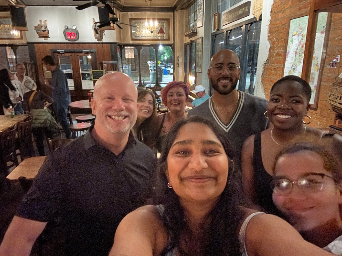 A smiling group of Athens Scoop Dinner Club guests at a local restaurant